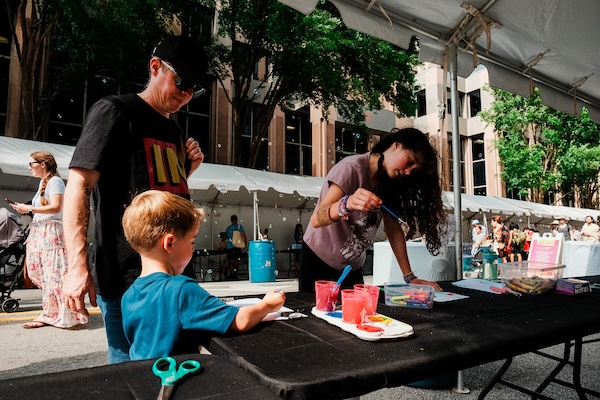 Visitors browsing juried art booths at Artsplosure